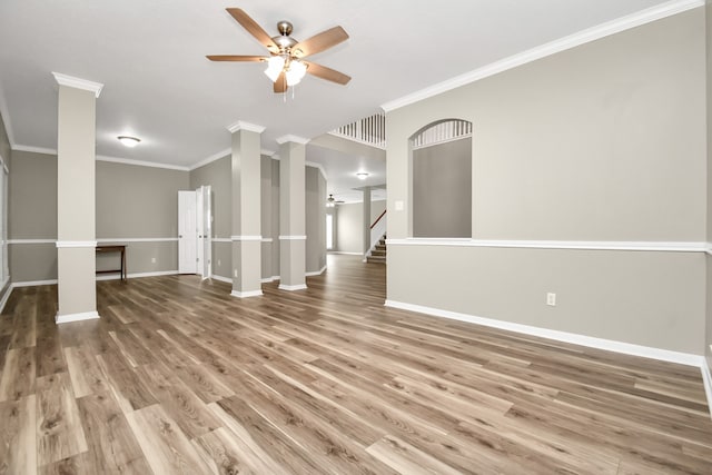 spare room featuring decorative columns, hardwood / wood-style floors, ceiling fan, and ornamental molding