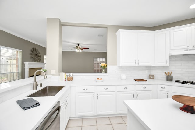 kitchen with tasteful backsplash, ornamental molding, light tile patterned floors, sink, and white cabinets