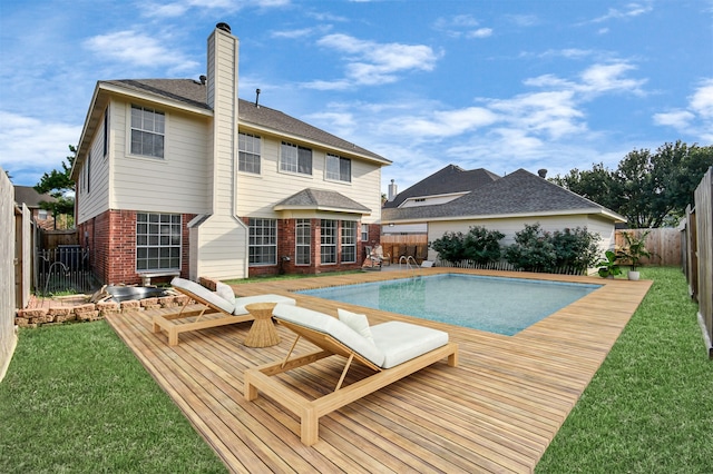 view of pool with a lawn and a deck