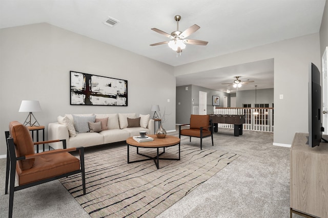 carpeted living room featuring ceiling fan and vaulted ceiling