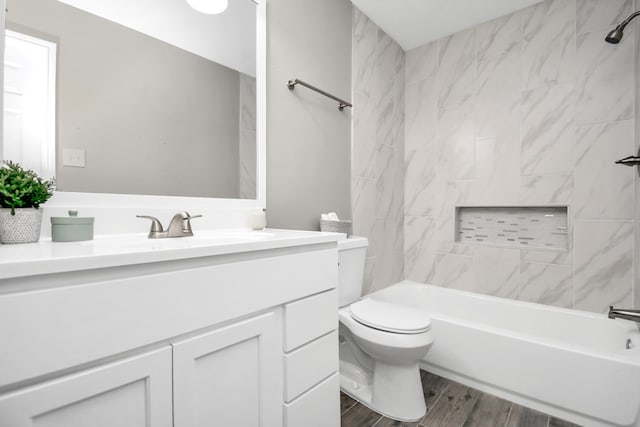 full bathroom with toilet, tiled shower / bath combo, vanity, and wood-type flooring