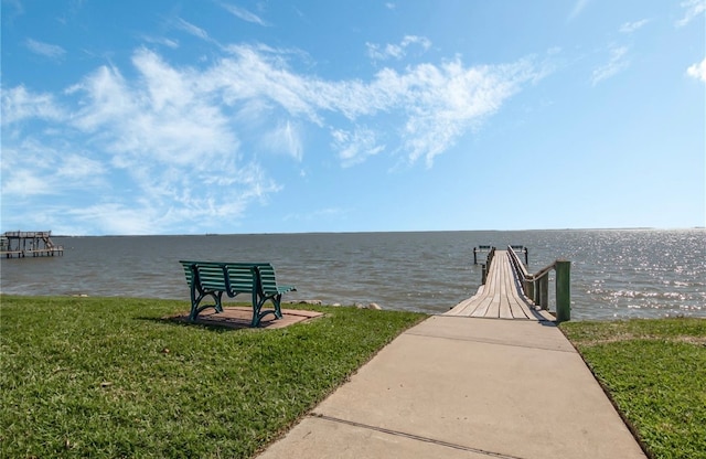 dock area featuring a water view and a lawn