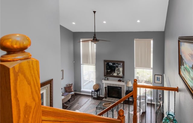 living room featuring hardwood / wood-style flooring, a tiled fireplace, plenty of natural light, and vaulted ceiling