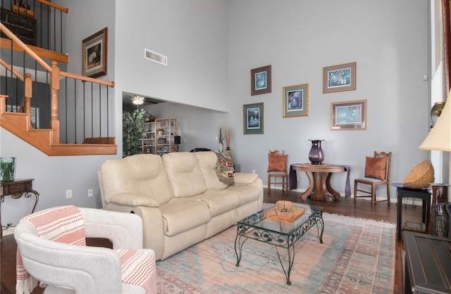 living room featuring a high ceiling and wood-type flooring