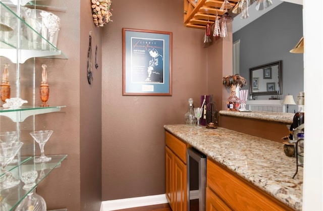 bar with wine cooler and light stone countertops