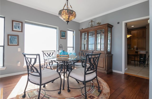 dining room with ornamental molding and dark hardwood / wood-style floors