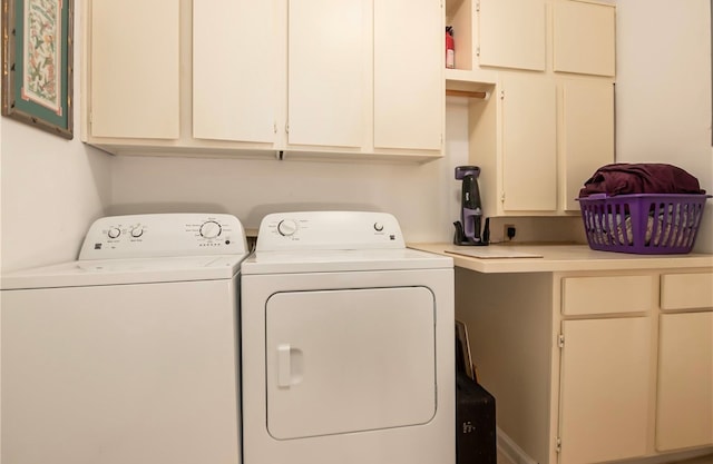 laundry area with separate washer and dryer and cabinets