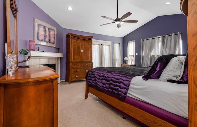 bedroom with vaulted ceiling, light carpet, a fireplace, and ceiling fan