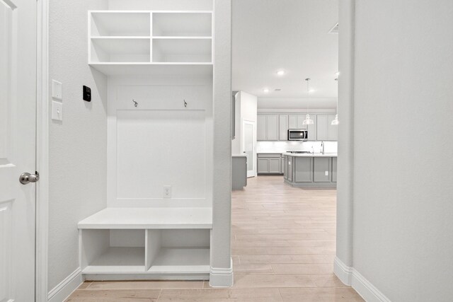 mudroom featuring sink and light hardwood / wood-style floors