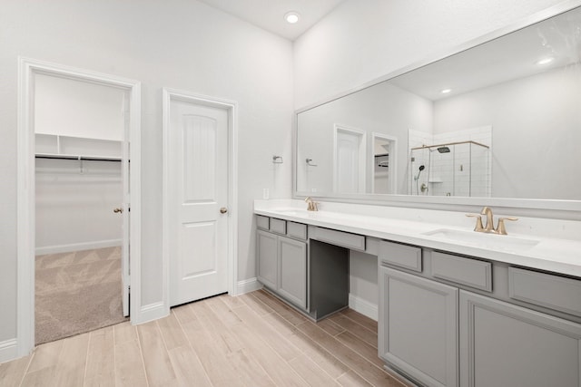 bathroom featuring vanity, a shower with shower door, and wood-type flooring