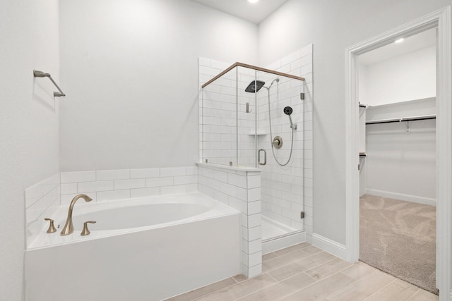 bathroom featuring shower with separate bathtub