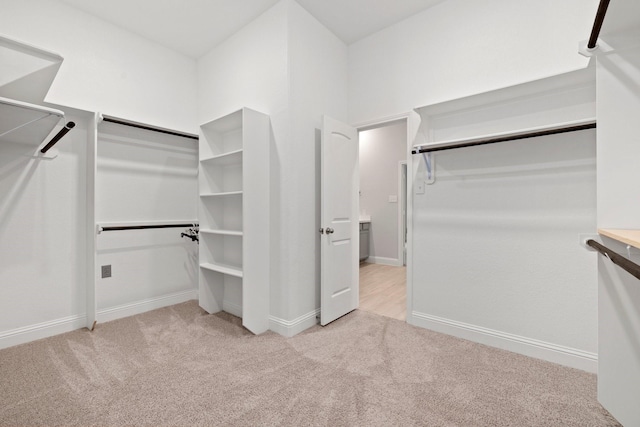 walk in closet featuring light carpet