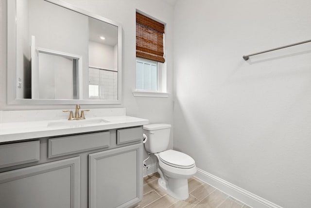 bathroom with toilet, vanity, and hardwood / wood-style flooring