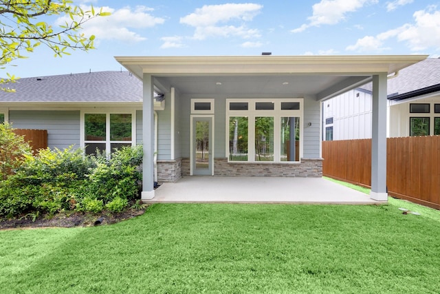 rear view of property with a yard and a patio