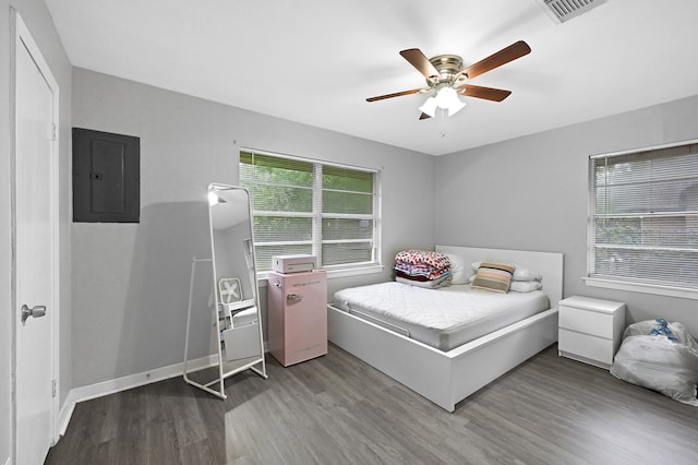 bedroom featuring electric panel, hardwood / wood-style flooring, and ceiling fan