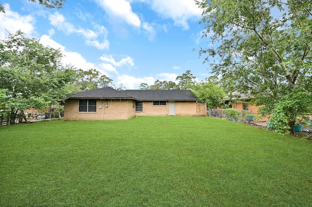 rear view of house featuring a yard