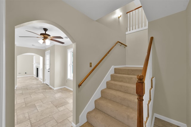 stairs featuring ceiling fan