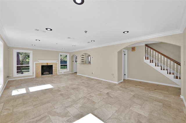 unfurnished living room with ornamental molding and a tiled fireplace