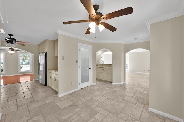 interior space with ornamental molding and ceiling fan