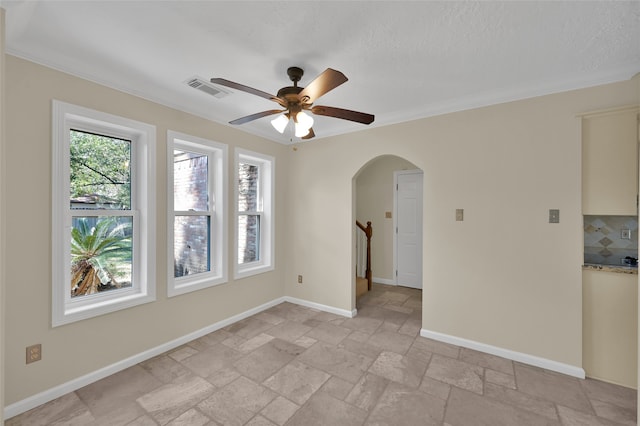 spare room featuring crown molding, a textured ceiling, and ceiling fan