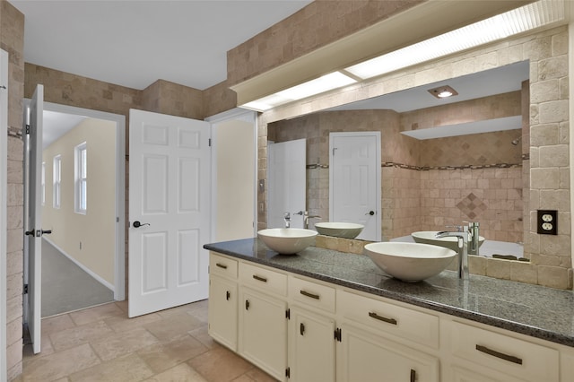 bathroom with vanity, a shower, and tile walls