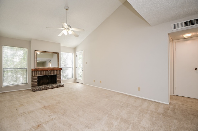 unfurnished living room featuring ceiling fan, a fireplace, high vaulted ceiling, and light colored carpet