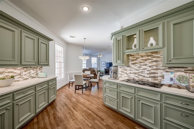 kitchen featuring black electric cooktop, ceiling fan, backsplash, and hanging light fixtures