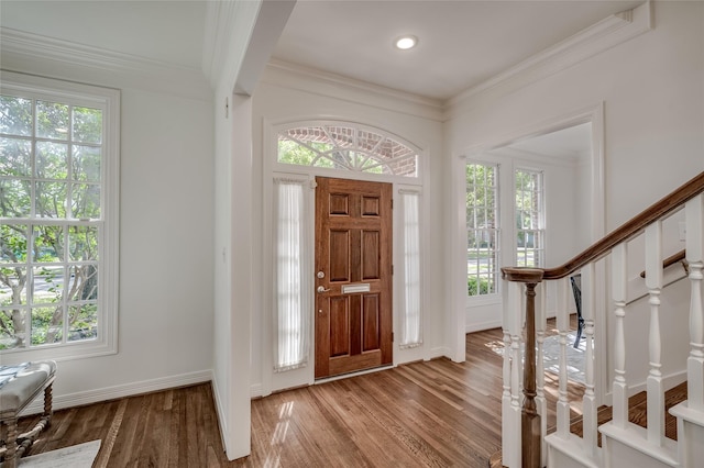 entrance foyer with light wood-type flooring, a healthy amount of sunlight, and crown molding