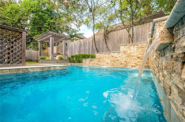 view of pool with pool water feature and a pergola