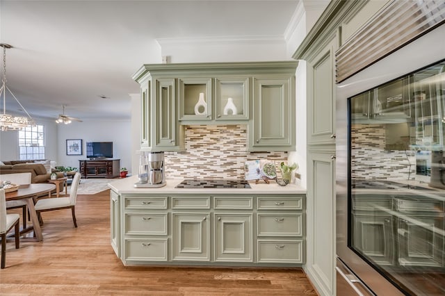 kitchen with pendant lighting, black electric cooktop, backsplash, and crown molding