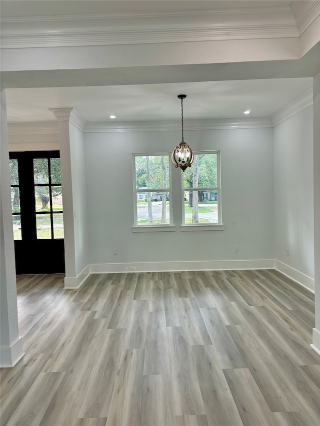 empty room with crown molding, light wood-type flooring, and french doors