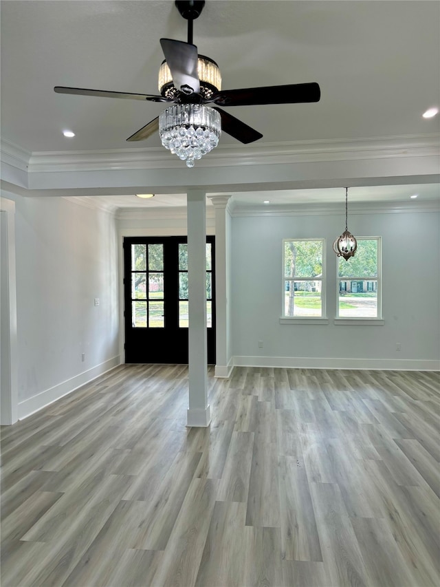 interior space featuring ornamental molding, light hardwood / wood-style flooring, ornate columns, and plenty of natural light