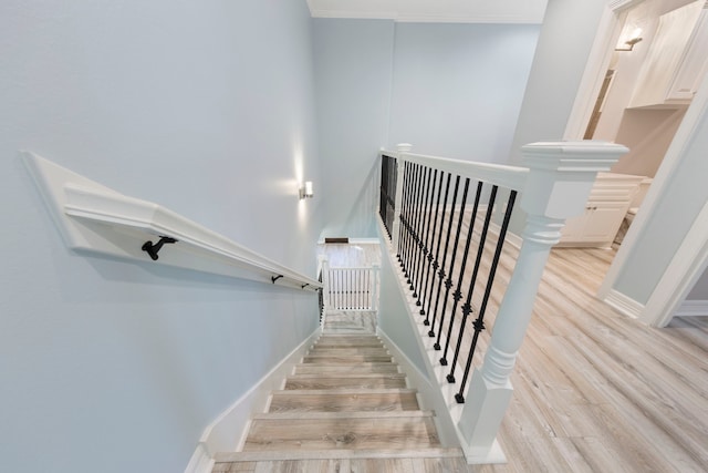 staircase featuring crown molding and hardwood / wood-style floors