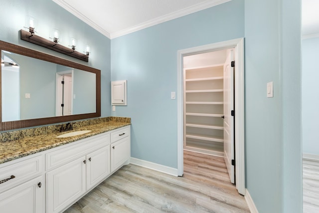 bathroom with vanity, ornamental molding, and hardwood / wood-style flooring