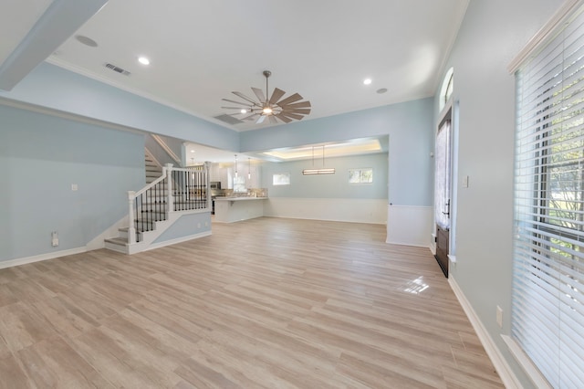 unfurnished living room featuring ceiling fan, ornamental molding, and light wood-type flooring