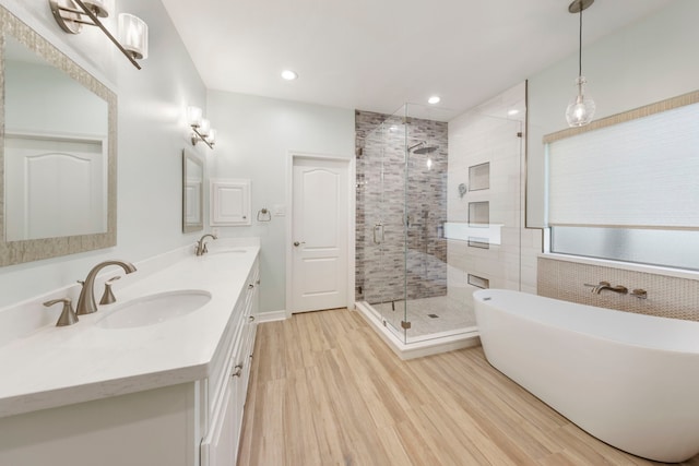 bathroom featuring vanity, wood-type flooring, and plus walk in shower