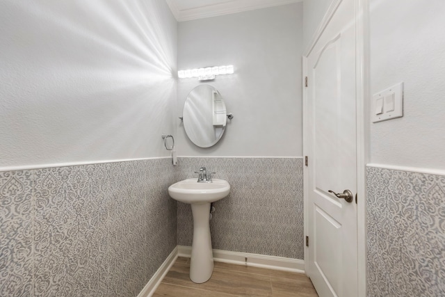 bathroom with hardwood / wood-style floors, crown molding, and sink