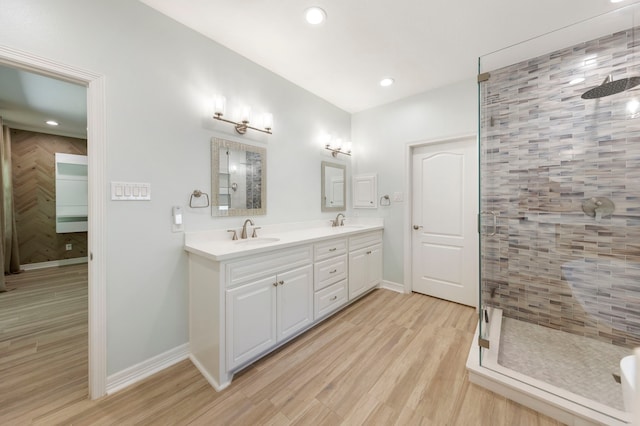 bathroom featuring wood-type flooring, vanity, and a shower with door