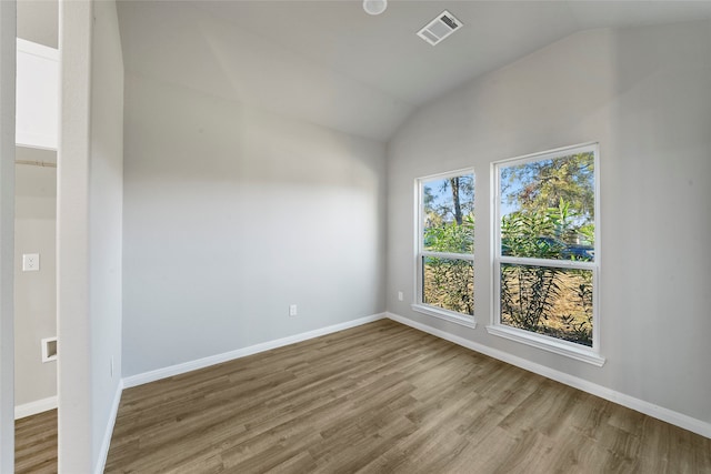 empty room with lofted ceiling and wood-type flooring