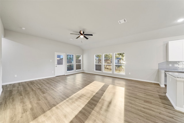 unfurnished living room featuring vaulted ceiling, light hardwood / wood-style flooring, and ceiling fan