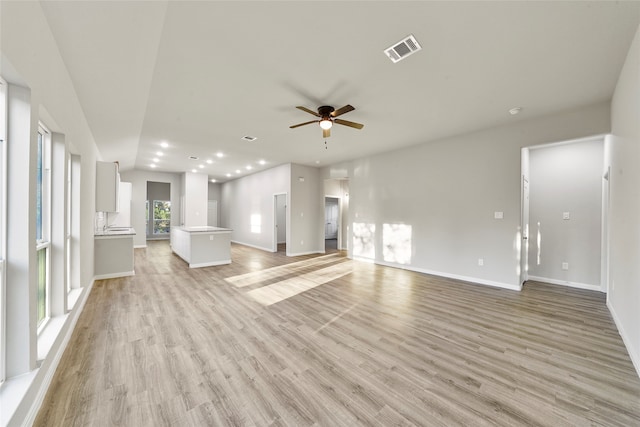 unfurnished living room featuring ceiling fan and light wood-type flooring