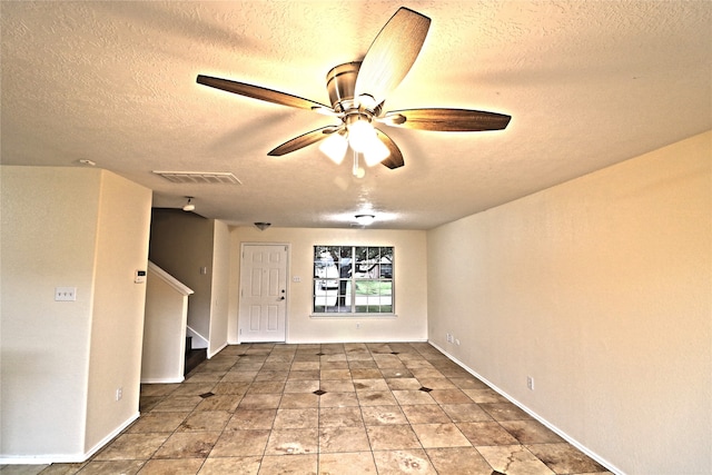 empty room featuring a textured ceiling and ceiling fan