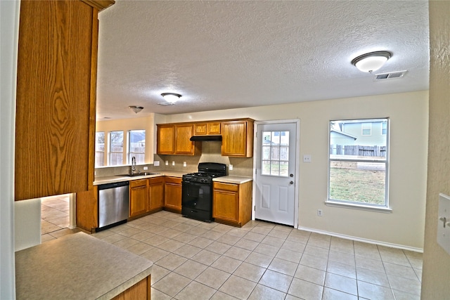 kitchen featuring stainless steel dishwasher, sink, black gas stove, and a textured ceiling