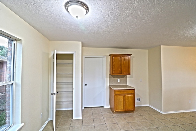 kitchen with a textured ceiling and light tile patterned floors