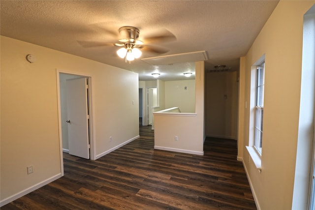 unfurnished room with plenty of natural light, a textured ceiling, dark hardwood / wood-style floors, and ceiling fan