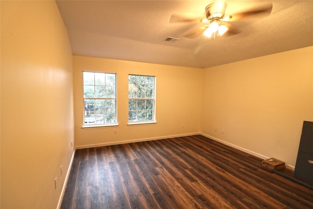 spare room featuring dark wood-type flooring, ceiling fan, and a textured ceiling