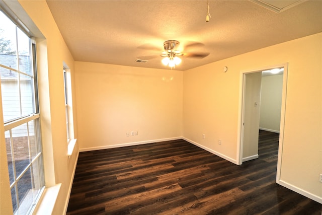 empty room featuring a textured ceiling, dark wood-type flooring, and ceiling fan