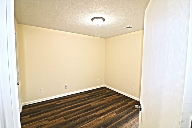 unfurnished room with dark hardwood / wood-style floors and a textured ceiling