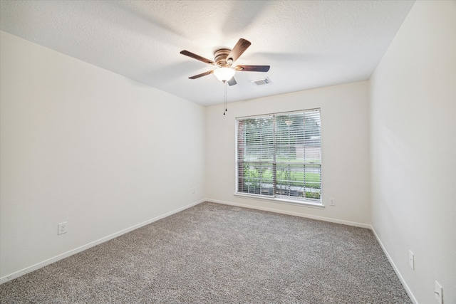 carpeted spare room with a textured ceiling and ceiling fan