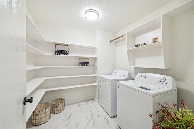 laundry area with a textured ceiling and separate washer and dryer